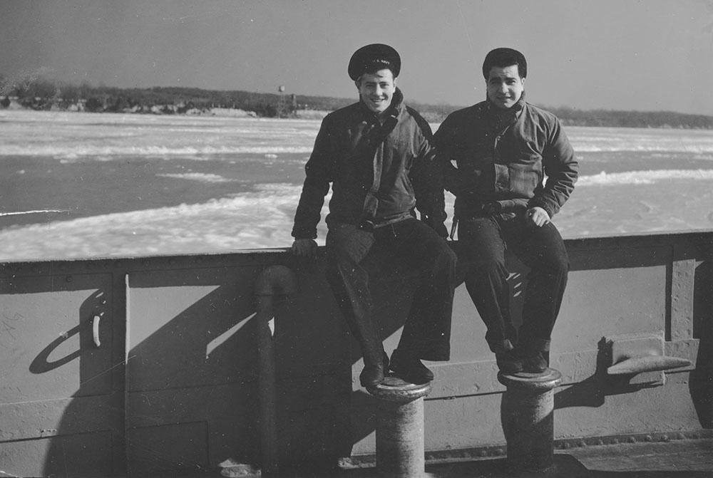 Photo of Teddy Bertone and Frank DeRupo sitting on the side of the Zircon, possibly in Argentia, Newfoundland, Canada.